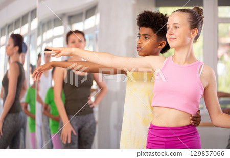 Teenage girl practicing ballet positions in pair with boy in dance studio 129857066