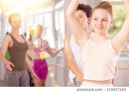 Teenage girl and boy practicing ballet moves in pair in dance studio 129857164