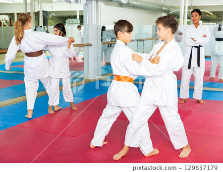 Young girls and boys sparring during karate training 129857179