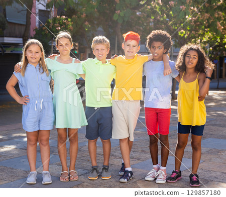 Group portrait of happy tweenagers standing on city street 129857180