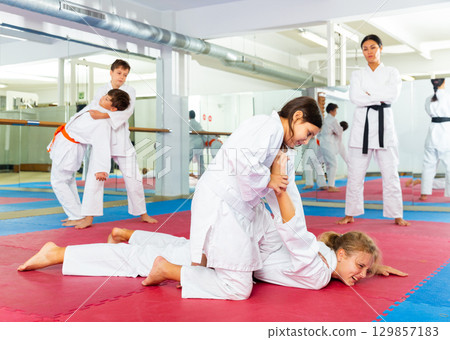 Boys performing arm lock movement during karate training 129857183