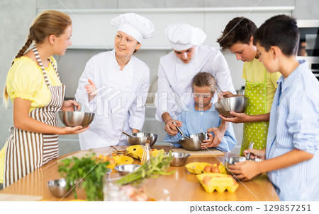 Chef apprentices learn how to properly beat eggs with a whisk in cooking class Chef apprentices learn how to properly beat eggs with a whisk in cooking class 129857251