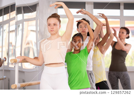 Woman teacher corrects teenagers in second position 129857262