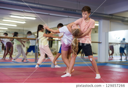 Kids learning self-defence moves in gym Kids learning self-defence moves in gym 129857266