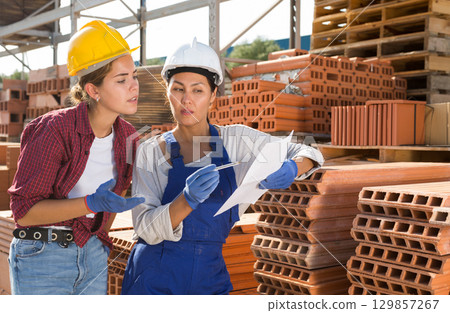 Couple of female wokers checking order list Couple of female wokers checking order list 129857267