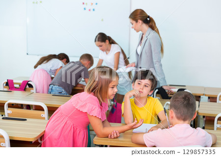 Preteen schoolchilds working in groups at lesson 129857335