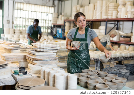 Young woman potter with new crafted ceramic bowls 129857345