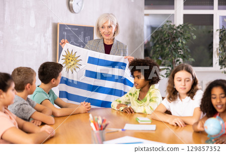 Mature female teacher tells the pupils the history of Uruguay Mature female teacher tells the pupils the history of Uruguay 129857352