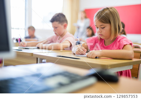 Schoolgirl sitting in classroom during lesson in elementary school Schoolgirl sitting in classroom during lesson in elementary school 129857353