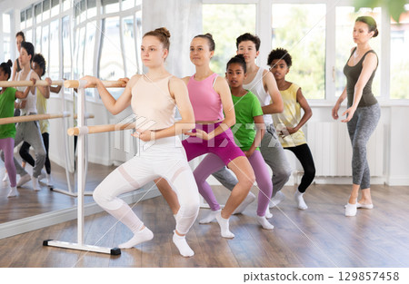 Teenage girl practicing plie position of ballet during choreography classes 129857458