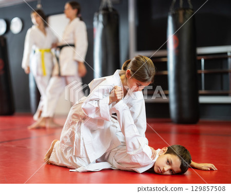 Teenage boy and girl practicing karate Teenage boy and girl practicing karate 129857508
