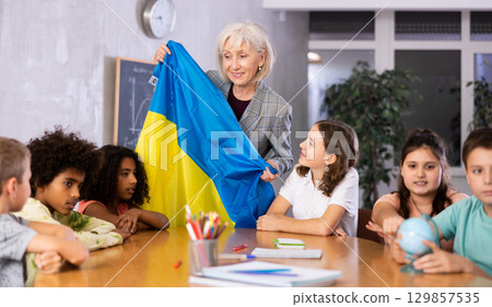 Friendly female teacher tells the pupils the history of Ukraine 129857535