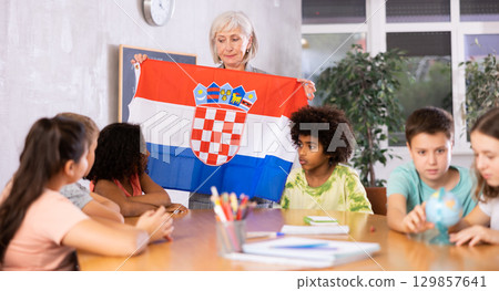 Female teacher showing croatian flag to kids in geography class 129857641
