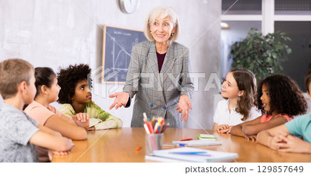 Female teacher giving kids a lesson in school classroom 129857649