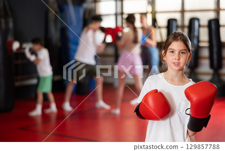 Teenage girl in boxing gloves in training Teenage girl in boxing gloves in training 129857788