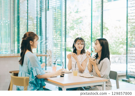 Three women having lunch at a cafe 129857800