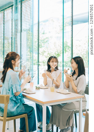 三位女士在咖啡館吃午餐 129857801