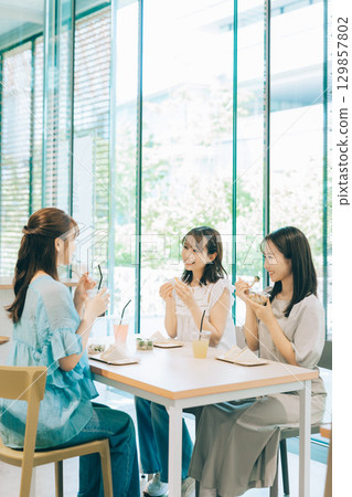 Three women having lunch at a cafe 129857802