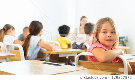 Schoolgirl sitting in classroom during lesson in elementary school 129857873