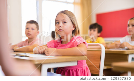 Schoolgirl sitting in classroom during lesson in elementary school Schoolgirl sitting in classroom during lesson in elementary school 129857880