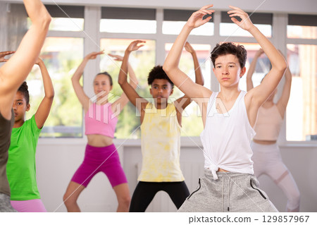 Group of teenage dancers practice plie 129857967