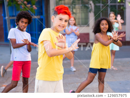 Preteen boy dancing with friends on summer city street Preteen boy dancing with friends on summer city street 129857975