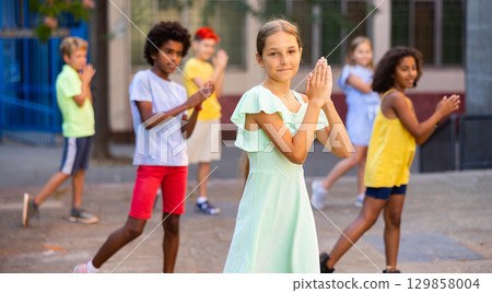 Children exercising contemporary dance moves outdoors Children exercising contemporary dance moves outdoors 129858004