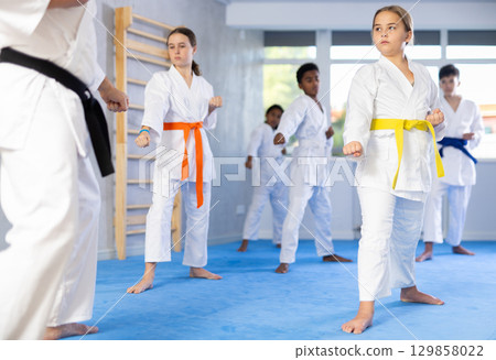 Group of children train karate techniques 129858022