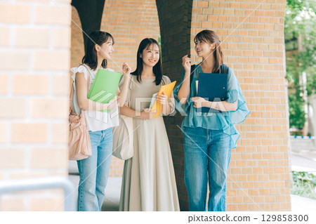 Three female university students walking on campus Three female university students walking on campus 129858300