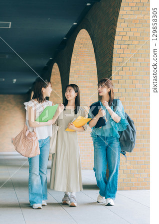 Three female university students walking on campus 129858305
