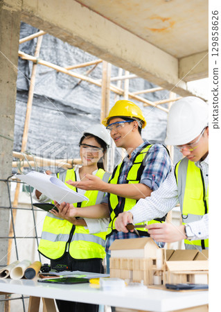 Engineer teams meeting working together wear worker helmets hardhat on construction site in city. 129858626