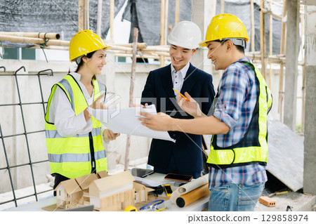 Engineer teams meeting working together wear worker helmets hardhat on construction site 129858974