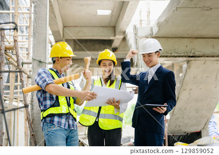 Contractor and architect looking at plan, tablet, laptop and talking about working on big project. Contractor and architect looking at plan, tablet, laptop and talking about working on big project. 129859052