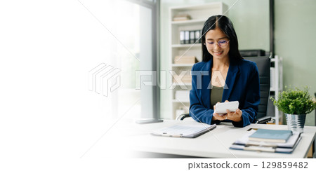 Asian woman sitting at a desk using a laptop computer Navigating Finance and Marketing Asian woman sitting at a desk using a laptop computer Navigating Finance and Marketing 129859482