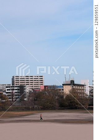在陽光明媚的日子裡,人們在公寓大樓的公園散步 在陽光明媚的日子裡,人們在公寓大樓的公園散步 129859551