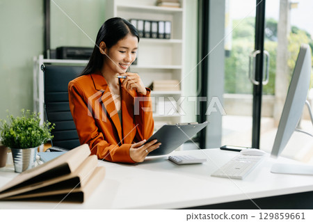 Asian woman sitting at a desk using a laptop computer Navigating Finance and Marketing Asian woman sitting at a desk using a laptop computer Navigating Finance and Marketing 129859661