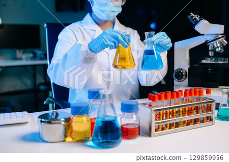 Scientists, beakers, and microscopes in cutting-edge research. Perfect for science and technology projects. 129859956