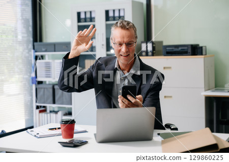 Mature business man executive manager looking at laptop watching online webinar training or having virtual meeting Mature business man executive manager looking at laptop watching online webinar training or having virtual meeting 129860225