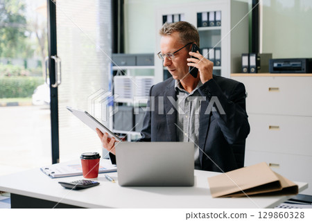 Mature business man executive manager looking at laptop watching online webinar training or having virtual meeting Mature business man executive manager looking at laptop watching online webinar training or having virtual meeting 129860328