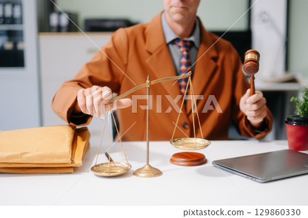 justice and law concept. Male judge in a courtroom the gavel, working with smart phone and laptop 129860330