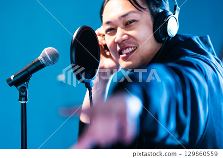 A young man undergoing voice training and recording A young man undergoing voice training and recording 129860559