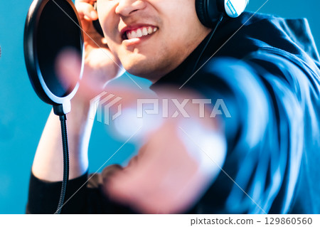 A young man undergoing voice training and recording. No face. 129860560