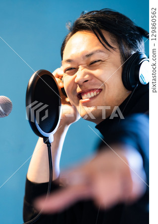 A young man undergoing voice training and recording 129860562
