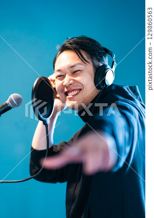 一名年輕人正在接受聲音訓練和錄音 一名年輕人正在接受聲音訓練和錄音 129860563