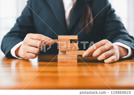 Business risk control concept, Businesswoman protect wooden block fall to planning and strategy in risk to business alternative and prevent. investment insurance business. 129860628