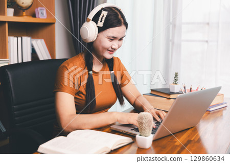Homeschool Asian girl student learning virtual internet online class from school teacher by remote meeting. Female teaching math by headphone. education concept. student with computer study at school Homeschool Asian girl student learning virtual internet online class from school teacher by remote meeting. Female teaching math by headphone. education concept. student with computer study at school 129860634