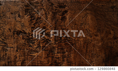 A background image of a long, dark brown board with a complex, rough grain pattern 129860848