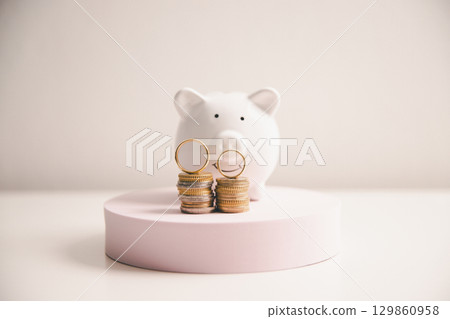 Save money for wedding and planning wedding concept. Sustainable financial goal for family life or married life. Miniature wedding on rows of rising coins, depicts savings or growth for new family. Save money for wedding and planning wedding concept. Sustainable financial goal for family life or married life. Miniature wedding on rows of rising coins, depicts savings or growth for new family. 129860958