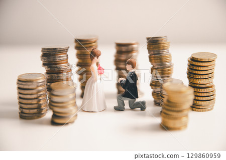 Save money for wedding and planning wedding concept. Sustainable financial goal for family life or married life. Miniature wedding on rows of rising coins, depicts savings or growth for new family. Save money for wedding and planning wedding concept. Sustainable financial goal for family life or married life. Miniature wedding on rows of rising coins, depicts savings or growth for new family. 129860959