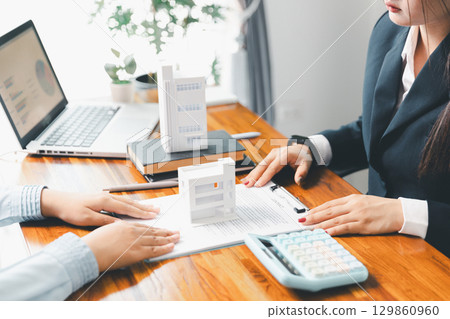 Home loan officer uses calculator with house plan loan real estate or property. important to loan calculator seek real estate, finance insurance advice ensure smart financial decisions for business. Home loan officer uses calculator with house plan loan real estate or property. important to loan calculator seek real estate, finance insurance advice ensure smart financial decisions for business. 129860960